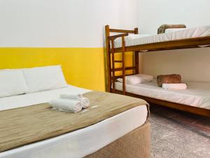 a room with two bunk beds with towels on it at Pousada Pura Vida in Bertioga