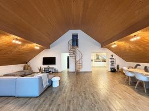 a living room with a blue couch and a wooden ceiling at XXL Penthouse - 240qm - 6 rooms - priv Parking- MalliBase Apartments in Garbsen