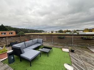 a patio with a couch and a table on a roof at XXL Penthouse - 240qm - 6 rooms - priv Parking- MalliBase Apartments in Garbsen +17 photos