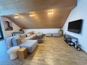 a living room with a couch and a flat screen tv at XXL Penthouse - 240qm - 6 rooms - priv Parking- MalliBase Apartments in Garbsen