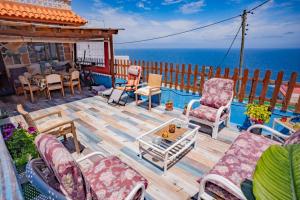 a deck with chairs and a table and the ocean at Estudios kylie y Evelyn in Santa Cruz de Tenerife