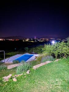 a yard with a swimming pool at night at Ventura apart in Estancia Vieja