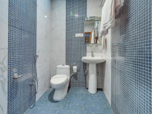 a blue tiled bathroom with a toilet and a sink at Hotel River View Resort in Pahalgām