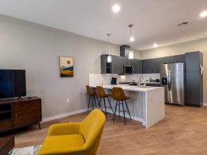 una cocina con una silla amarilla y una barra de cocina en 310 Brand New 1 Bedroom 1 Bath 1 Full Kit 1 Liv, en Dunellen