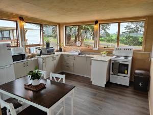 a large kitchen with white appliances and a table at Apartment 1 in Auckland