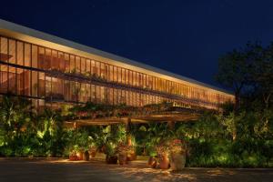 a building with potted plants in front of it at night at The Riviera Maya EDITION at Kanai in Playa del Carmen