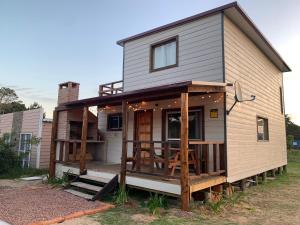 a tiny house with a porch and a deck at Laslu in Punta Del Diablo