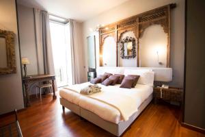 una camera da letto con un grande letto bianco e una grande finestra di Art Hotel Boston a Torino