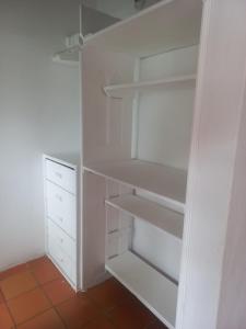 a white closet with white shelves and a floor at Hotel Villa Paz in Villa de Leyva