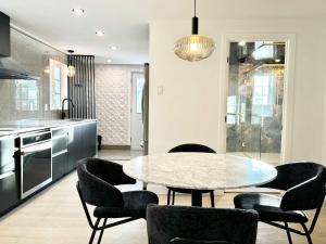 una cucina con un tavolo e sedie in una stanza di Les Suites des Chutes - La Royale a Boischâtel
