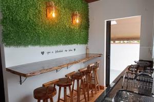 a bar with stools and a green wall at Blaues Haus 2 in Pomerode