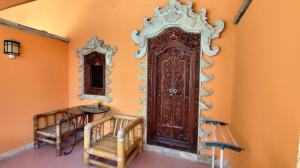 eine große Holztür in der Ecke eines Zimmers in der Unterkunft Keyani Bungalows Lovina in Lovina