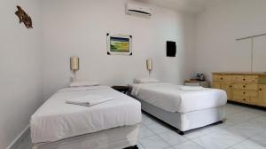 1 Schlafzimmer mit 2 Betten und einem TV an der Wand in der Unterkunft Keyani Bungalows Lovina in Lovina