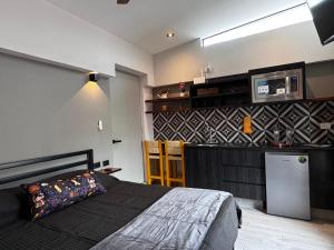 a bedroom with a bed and a kitchen with a refrigerator at Casa Tahíí in Querétaro