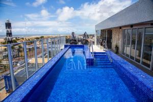 a swimming pool on top of a building with a lighthouse at Studio Completo a Beira Mar, Grand Smart Residence in Aracaju