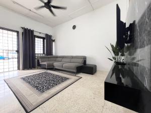 a living room with a couch and a tv at CikSiti homestay02 in Kajang