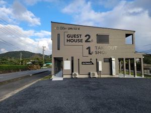a building with a guest house on the side of a road at 奄美ラッキー海の家 in Yoan