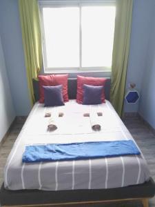 Una cama grande en una habitación con una ventana grande. en Chez Qaeko, en Lifou