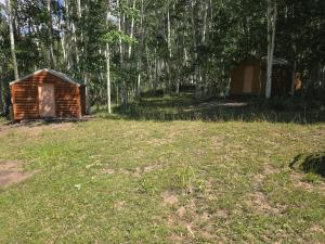 a log cabin in a field next to a forest at Camp Jackson Sleeping Cabin West in Monticello