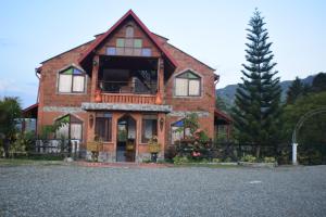 a brick house with a porch and a balcony at Finca Hotel Villa Mia in Girardota