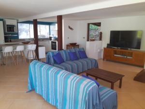 un salon avec un canapé et une télévision dans l'établissement Villa Blue Horizon Moorea, à Teavaro