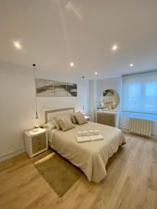 una camera da letto con un letto grande e una grande finestra di Apartamento de lujo River Suites a Santander