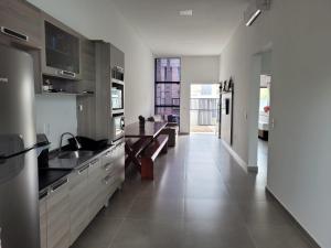 eine Küche mit Küchengeräten aus Edelstahl und Fliesenboden in der Unterkunft Casa com piscina e espaço gourmet 300m do mar in Barra Velha