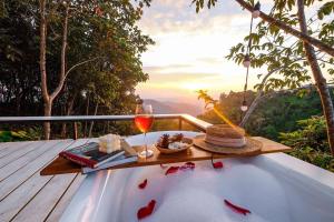 Ban Huai KhaiにあるOne villa coffee farm stay 1のワイングラスと帽子のある温水浴槽