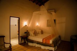 a bedroom with a bed with a mosquito net at Villa Leela Bentota in Induruwa +51 photos