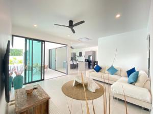 una sala de estar con un sofá y una mesa en MANEE Jasmine Pool Villa, Bangrak, Bo Phut, Fisherman's Village, en Bangrak Beach