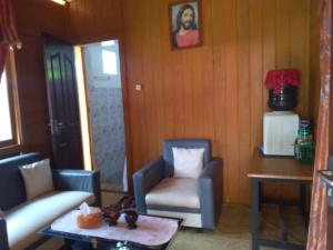 un soggiorno con due sedie e un tavolo di MAXWELL Pondok Wisata a Likupang