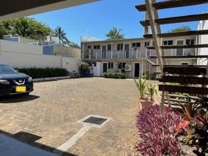 a car parked in a parking lot in front of a building at Whitehaven Beachfront Holiday Units in Airlie Beach