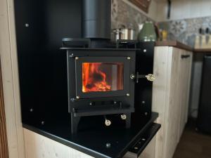 a stove in a kitchen with a fire in it at Maringotka u Krkavčích skal in Křižany