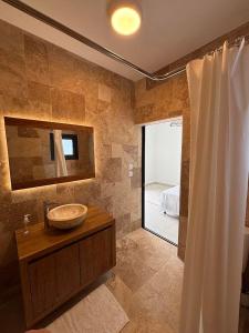 a bathroom with a sink and a shower at Les Roses du Désert in Étang-Salé