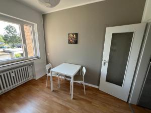 a white table and chairs in a room with a window at EMAS4 Wohnung mit 2 Einzelbetten, Küche in Krefeld