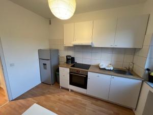 a kitchen with white cabinets and a refrigerator at EMAS4 Wohnung mit 2 Einzelbetten, Küche in Krefeld