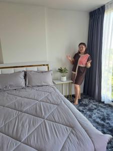 a woman standing next to a bed in a bedroom at Cybiq Ratchada 32 by Pikul in Bangkok +16 photos