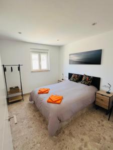 a bedroom with a large bed with orange towels on it at Renbeck lets 1 in Urcal
