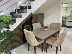 a dining room with a wooden table and chairs at HST - 3BED Duplex Chevron - Lekki in Ikuata