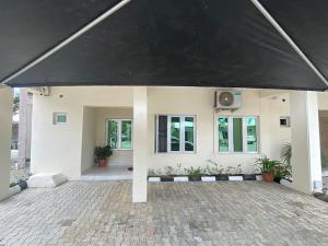 a white house with a large black roof at HST - 3BED Duplex Chevron - Lekki in Ikuata