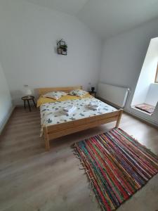 a bedroom with a bed and a rug at Magic Rooms in Gura Teghii