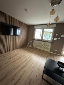 an empty living room with wood floors and a tv at Ferienhaus Pirmasens in Pirmasens