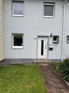 a gray house with a white door and a yard at Ferienhaus Pirmasens in Pirmasens