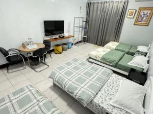 Changhua County彰濱伸港民宿的一间卧室，配有两张床、一张桌子和一台电视