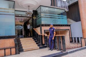 a man standing in front of a building at Sleep Inn Hotel - City Centre in Dar es Salaam