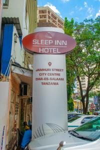 a sign for a sleep inn hotel on a street at Sleep Inn Hotel - City Centre in Dar es Salaam