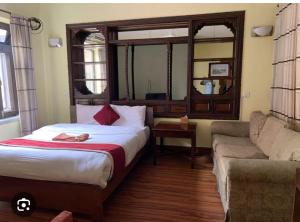 a hotel room with a bed and a couch at Buddha Home Nepal in Thapathali
