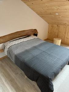 a bed in a room with a wooden ceiling at Gîte pied du mont fourcat in Mercus-Garrabet