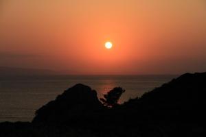 a sunset over the ocean with the sun in the sky at Joya in Ishigaki Island