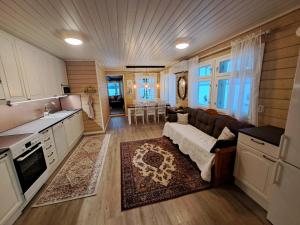 a kitchen and living room with a couch and a table at Holiday Home Joutsen in Parikkala